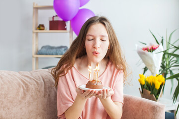 young woman looking at birthday cake with candle