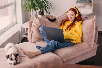 Relaxing young woman using laptop in living room