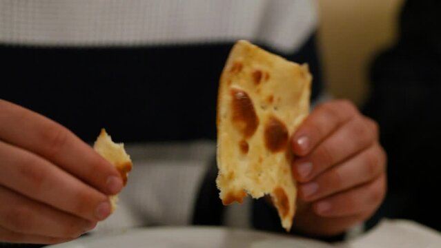Taking a piece of indian bread with two hands