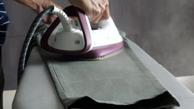 Man hand steam iron cloths 