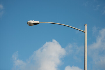 street lamp post with blue sky and white clouds - obrazy, fototapety, plakaty