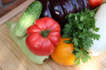 Tomato,, cucumber, zucchini on background of wooden boards. Organic vegetables.