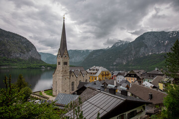 Fototapeta na wymiar Beautiful church in Hallstatt, Austria, viewed from a street in the city, with some houses in the foreground. Typical austrian city, famous for its picturesque look.