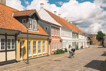 Beautiful old traditional houses in Odense old town, Denmark, Europe with girl with bike