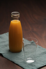 Fresh organic orange juice in tumbler glass on wood table