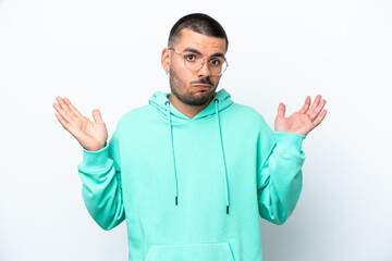 Young caucasian man isolated on white background having doubts while raising hands