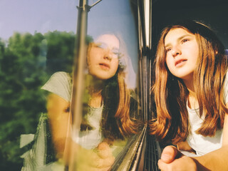 Chica mirando a través de la ventana del tres