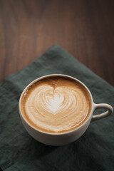 Fresh flat white with latte art in ceramic cup on wood table