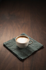 Fresh flat white with latte art in ceramic cup on wood table