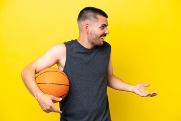 Young caucasian basketball player man isolated on yellow background with surprise expression while looking side