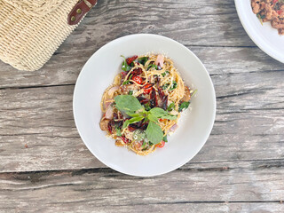 Spaghetti with dried chilli in white plate, top view.