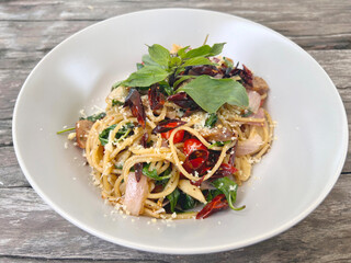 Spaghetti with dried chilli in white plate, top view.