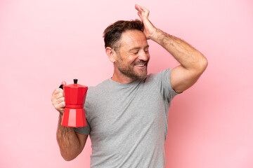 Middle age caucasian man holding coffee pot isolated on pink background has realized something and intending the solution