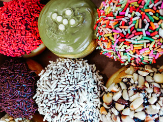assorted donuts with chocolate frosted, pink glazed and sprinkles donuts.