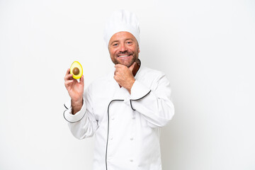 Chef man holding an avocado isolated on white background happy and smiling