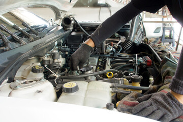 Technician fixing a car engine in the garage.