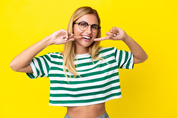 Blonde Uruguayan girl isolated on yellow background giving a thumbs up gesture