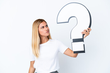 Blonde Uruguayan girl isolated on white background holding a question mark icon and having doubts