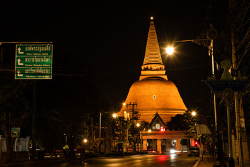 Navigator green metal plate Thai language lead to the great pogada nakhonpathom Thailand in nighttime with empty road on red light traffic