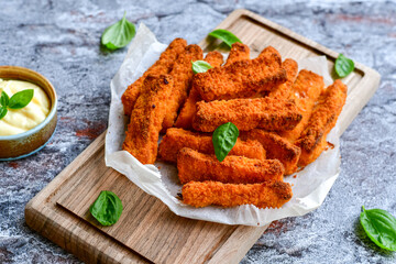 Close up of   Crispy breaded  deep fried fish fingers with breadcrumbs served  with remoulade sauce and  lemon Cod Fish Nuggets on rustic wood table background