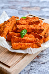 Close up of   Crispy breaded  deep fried fish fingers with breadcrumbs served  with remoulade sauce and  lemon Cod Fish Nuggets on rustic wood table background