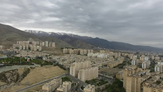 Aerial Drone View From The West Of Tehran And Its Tall Buildings Along With The Alborz Mountain Which Is Covered With Snow