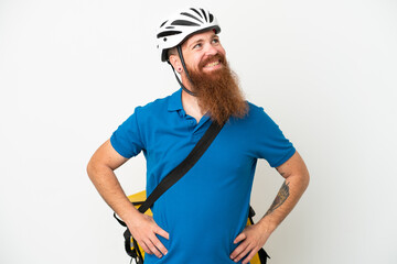 Young reddish caucasian man with thermal backpack isolate don white background posing with arms at hip and smiling