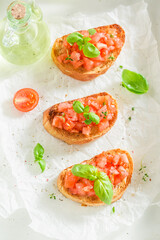 Crisp and healthy bruschetta with basil and tomatoes as snack.