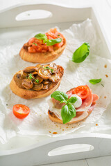 Crispy mix of bruschetta as classic snack for breakfast.