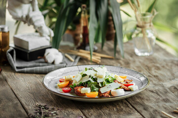 Gourmet chicken salad with parmesan on wooden background