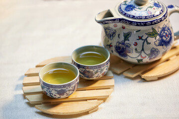 Cup of tea and teapot on wooden plate