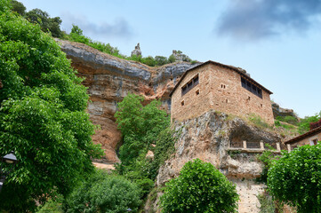 Fototapeta na wymiar Stone house over a big rock close of a cliff at Orbaneja del Castillo