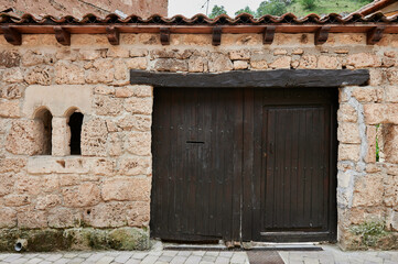 Stone facade with small old wooden door