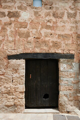 Stone facade with small old wooden door