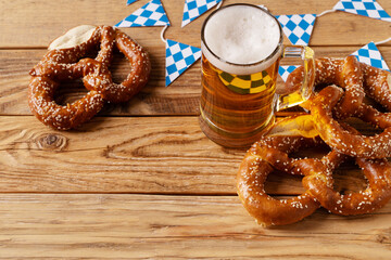 Oktoberfest concept with pretzel and blue simbol flag on wood background