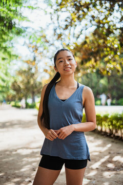 Portrait of asian fitness young woman looking at camera while she is in the park