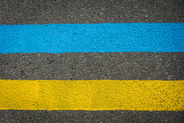 Yellow and blue double solid line on the road. Asphalt road with Ukrainian national colors. Flag of Ukraine. War in Ukraine