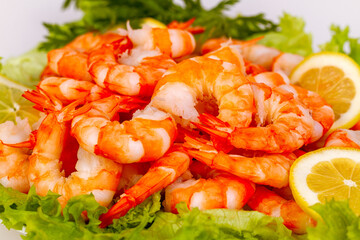Appetizing dish with boiled shrimp, lettuce and lemon.