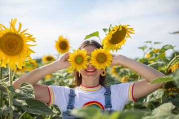 Stylish Ukrainian young girl in a field with sunflowers
