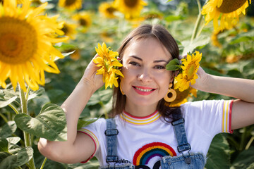 portrait of a beautiful young girl on a background field of sunflowers 