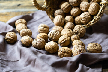 Whole walnuts on wooden rustic background, fresh walnut concept, close-up.