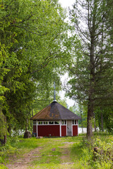 Typical Finnish little wooden shed with fire place along lake at the countryshide