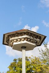 A nesting tower for swallows and buildings to protect...
