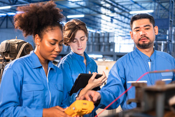 Engineer senior asian man and african woman wearing safety helmet working and checking machine  automotive part warehouse. Factory for the manufacture and processing.