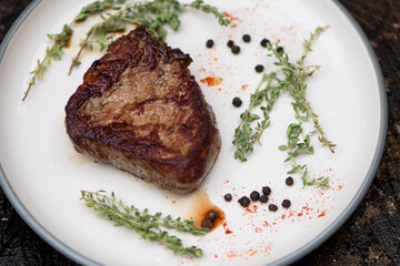 appetizing steak with spices, pepper and rosemary on a plate