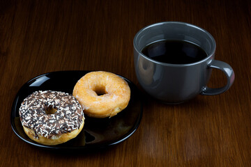 Donuts and Cup of Coffee on an Old Polished Wooden Table Top