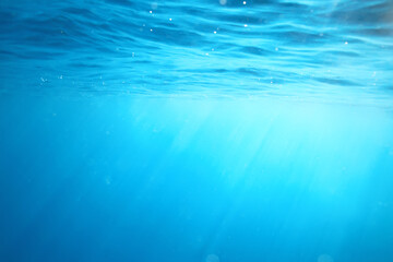 Obraz premium ocean underwater rays of light background, under blue water sunlight