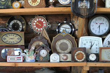 Different types of watches on the shelf. An old wall clock. Dusty dials in the watchmaker's...