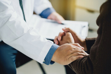 Psychiatrist or professional psychologist holding touching hands patient and comforts an anxious...