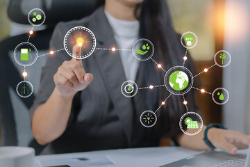 Hand touching ESG icon on virtual screen for environmental, social, and governance in sustainable and ethical business on a green background.